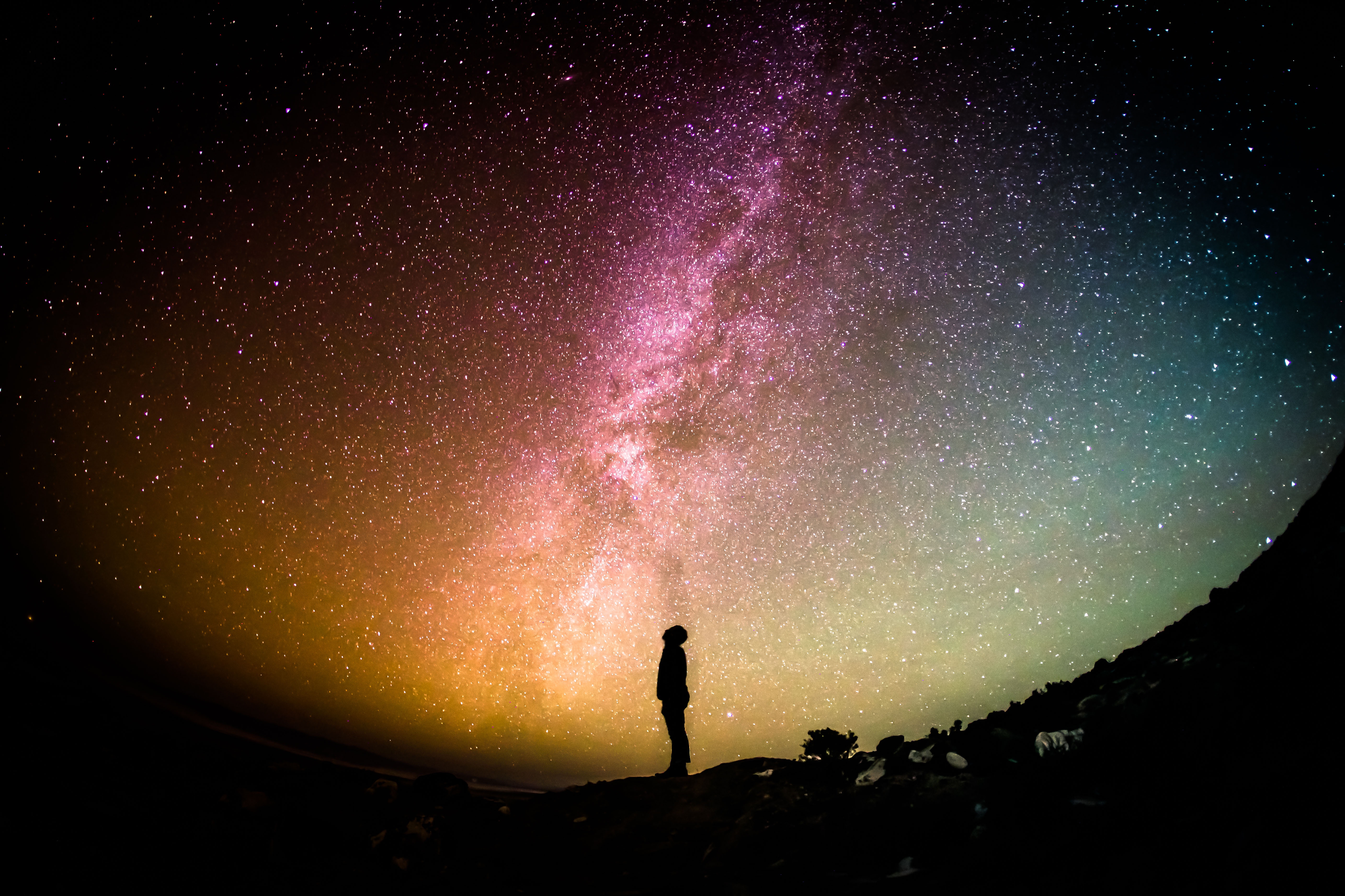 A human standing with the universe showcasing the milky way.